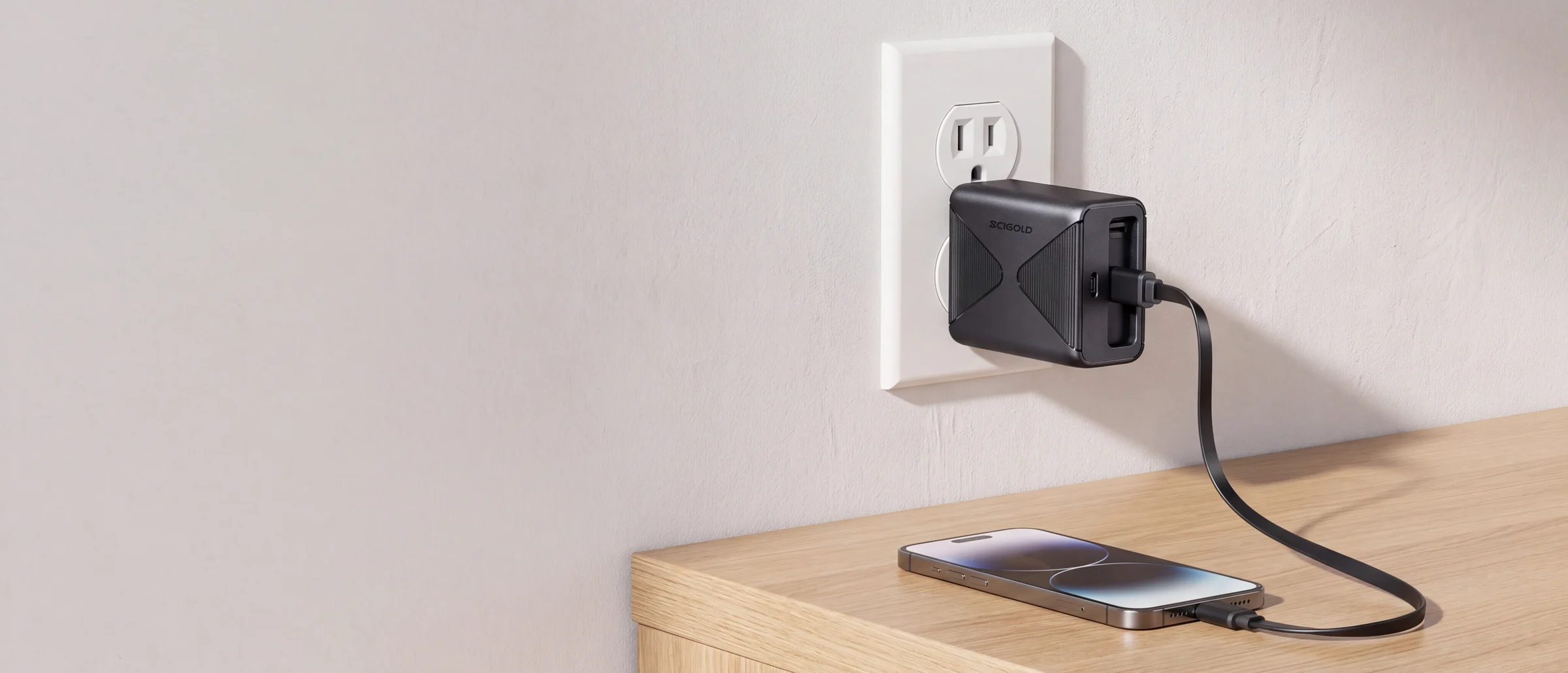 SCIGOLD 45W charger in a wall outlet, its retractable cable pulled out to a phone